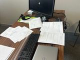 un bureau sur lequel se trouvent un ordinateur, un clavier, une souris et des papiers