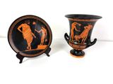 pair of black and orange vases with figures on them