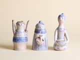 trois figurines en céramique assises les unes à côté des autres