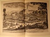 an open book with a picture of a town on it