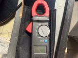a close up of a person holding a multimeter in their hand