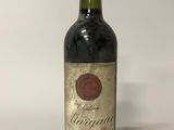 une vieille bouteille de vin posée sur une table blanche