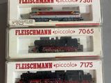 trois trains miniatures dans leurs boîtes, empilés les uns sur les autres