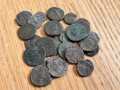 un tas de vieilles pièces romaines posées sur une table en bois