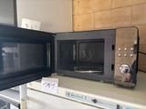 two microwaves sitting on top of each other on a counter