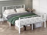 un lit blanc recouvert d'une couverture verte, dans une chambre