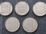 quatre types différents de pièces d'argent posées sur un tissu bleu