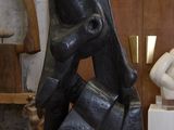 une sculpture noire posée sur une table en bois dans une pièce
