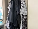 un porte-manteau sur lequel sont suspendus des vêtements, à côté d'un miroir