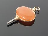a picture of an orange pendant on a black surface