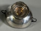 a silver tea pot and a silver tea pot on a table