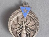 un gros plan d'une médaille d'argent sur laquelle figure une araignée