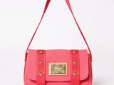 the small pink bag is sitting on a white surface
