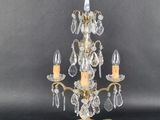 an antique brass and crystal three light chandelier