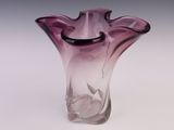 un vase en verre violet posé sur une table