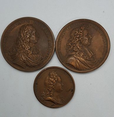 trois médaillons en bronze représentant deux hommes, dont l'un est un buste et l'autre est un buste