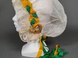 bonnet blanc orné d'un ruban jaune et vert et d'une bordure en dentelle