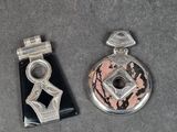 deux bijoux argentés et noirs posés sur une surface grise