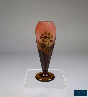 un vase en verre orné d'un motif floral, posé sur un socle
