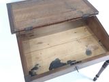 une vieille boîte en bois, dont le couvercle est ouvert, posée sur une table