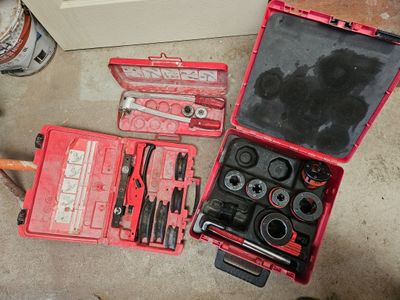 une trousse à outils posée par terre à côté d'un ordinateur portable