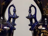 two blue vases with gold designs on them