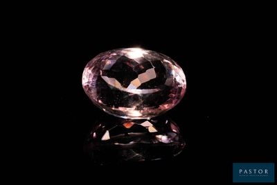 a close up of a pink diamond on a black surface
