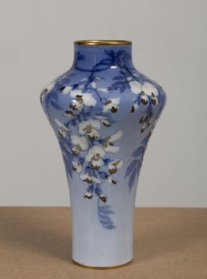 un vase bleu orné de fleurs blanches, posé sur une table