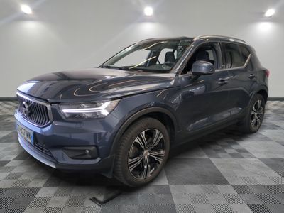un SUV Volvo bleu garé sur un sol à damier dans un showroom