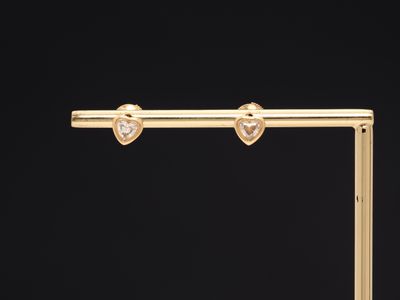 une paire de boucles d'oreilles en or ornées de diamants en forme de cœur
