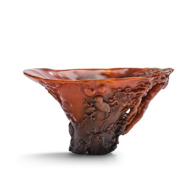 un bol en verre orange orné d'un motif sculpté sur le bord