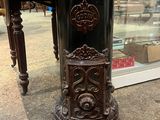 une très vieille horloge posée sur une table devant une vitrine