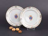 deux assiettes ornées d'un blason, à côté de noix