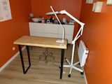 un bureau sur lequel est posée une lampe, dans un coin de la pièce