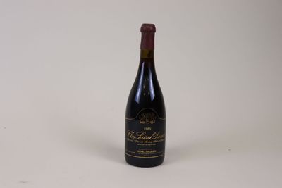 the bottle of wine is sitting on a white surface