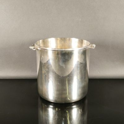 une casserole en acier inoxydable posée sur une table noire, sur fond gris