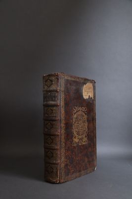 an old book sitting on top of a table next to a lamp