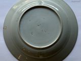 a white plate with a brown rim sitting on a table