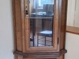 un meuble en bois avec une porte en verre dans une pièce