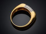a yellow gold ring with diamonds on a black background