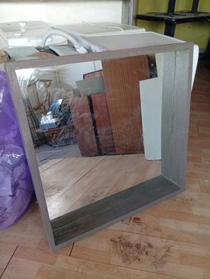 a mirror that is sitting on the floor next to a purple bag