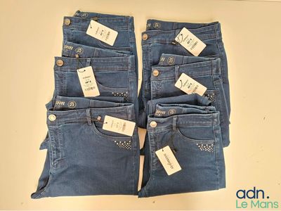 deux paires de jeans bleus, encore étiquetées, posées sur une table