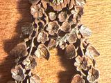 un gros plan d'un bracelet orné de fleurs posé sur une surface en bois