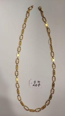 gros plan d'un collier en chaîne en or sur fond blanc