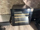 a wine cooler sitting on the floor next to a brick wall