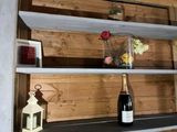 une bouteille de vin posée sur une étagère à côté d'une autre bouteille de vin