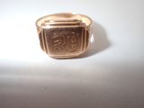 a gold signet ring with a small square signet on it