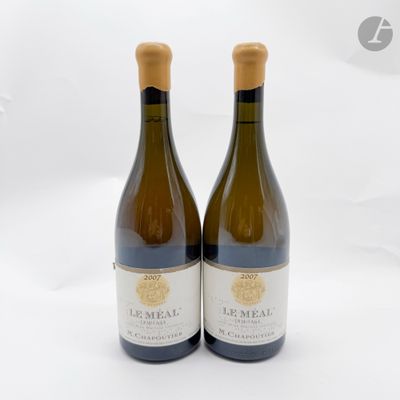 deux bouteilles de vin posées l'une à côté de l'autre sur une surface blanche