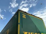un camion vert et jaune avec un oiseau qui vole dans le ciel