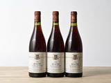 trois bouteilles de vin posées sur une table en bois